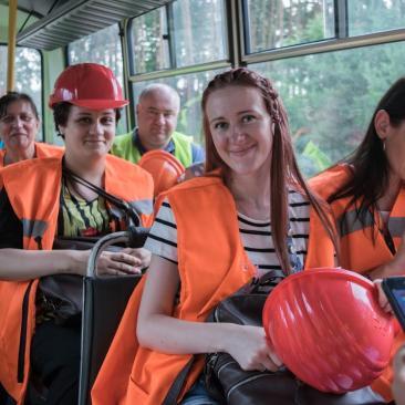 Ludzie w odzieży ochronnej jadą autobusem w lesie